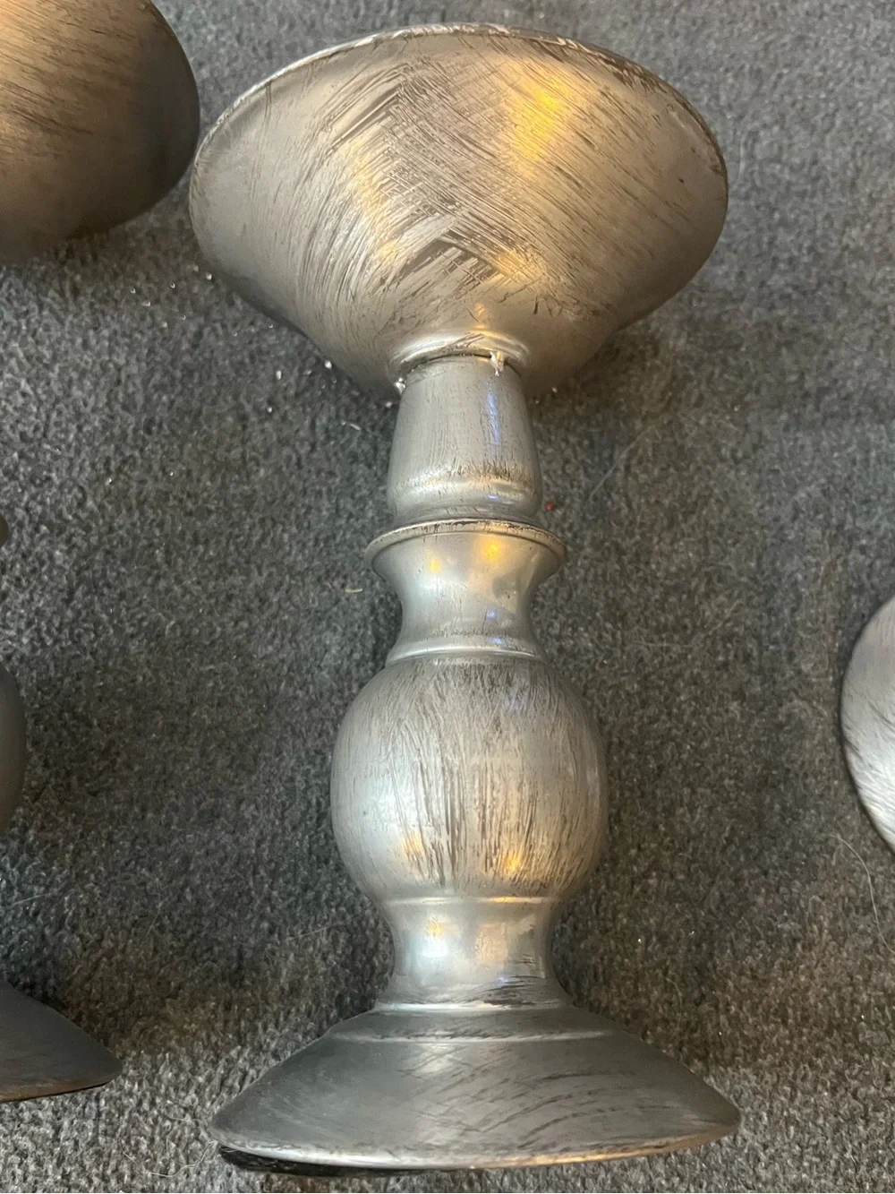 set of three silver-tone metal candlestick holders features a graduated design